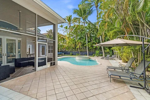 a view of a patio with table and chairs under an umbrella with a small yard