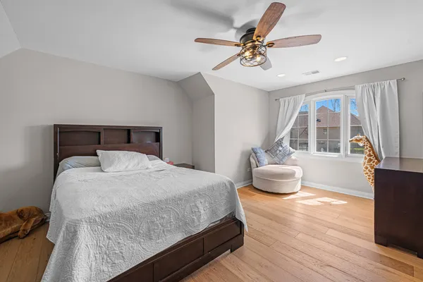 a bedroom with a bed and wooden floor