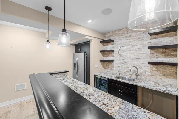 a kitchen with granite countertop a sink a counter space cabinets and stainless steel appliances