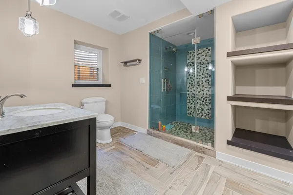 a bathroom with a sink a toilet and shower