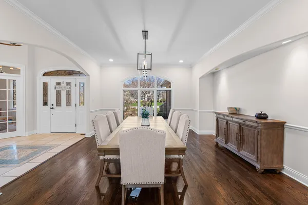 a dining room with furniture a chandelier and wooden floor