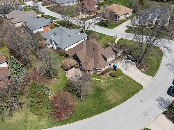 an aerial view of a house with a yard and lake