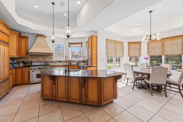a kitchen with stainless steel appliances granite countertop a stove a sink and a refrigerator