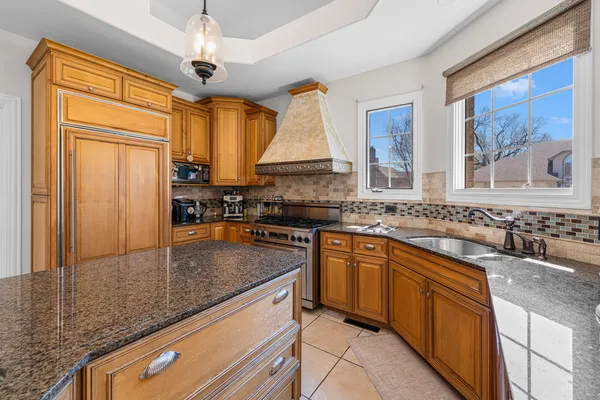 a kitchen with stainless steel appliances granite countertop a sink stove and refrigerator