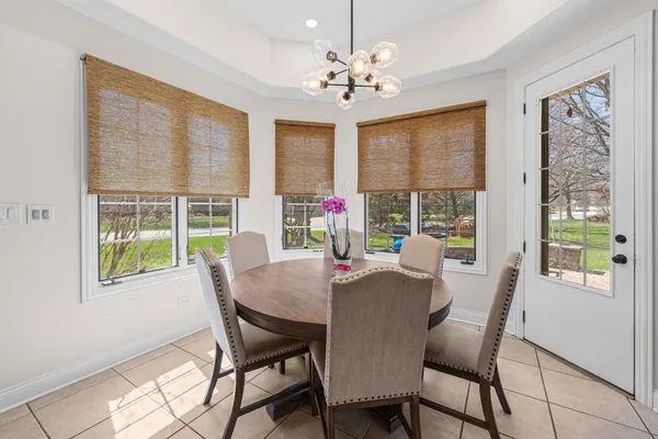 a view of a dining room with furniture a chandelier and wooden floor