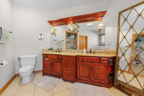 a spacious bathroom with a granite countertop toilet sink and mirror