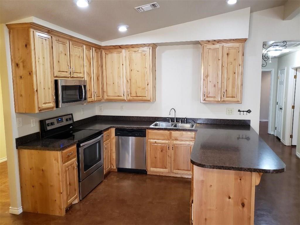a kitchen with granite countertop a sink a stove and a microwave