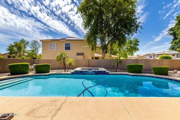 a view of a house with backyard and a tree