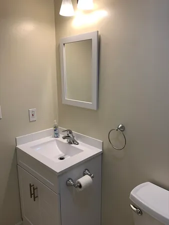 a bathroom with a sink a toilet and a mirror