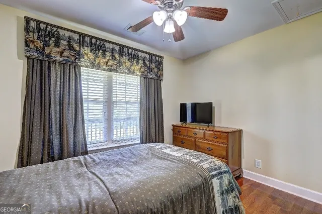 a bedroom with a bed and a flat tv screen on dresser
