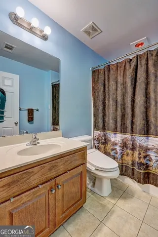 a bathroom with a double vanity sink toilet and a mirror