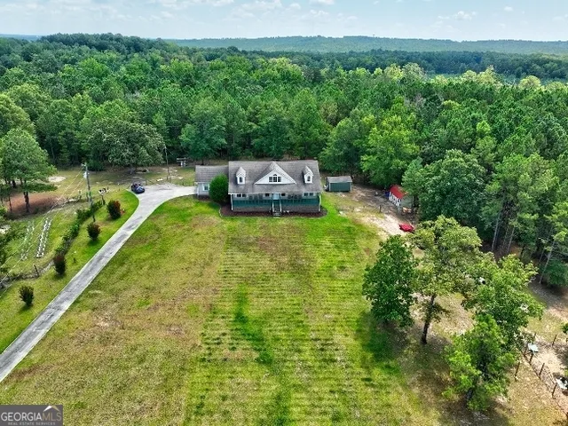 an aerial view of residential house with outdoor space and trees around