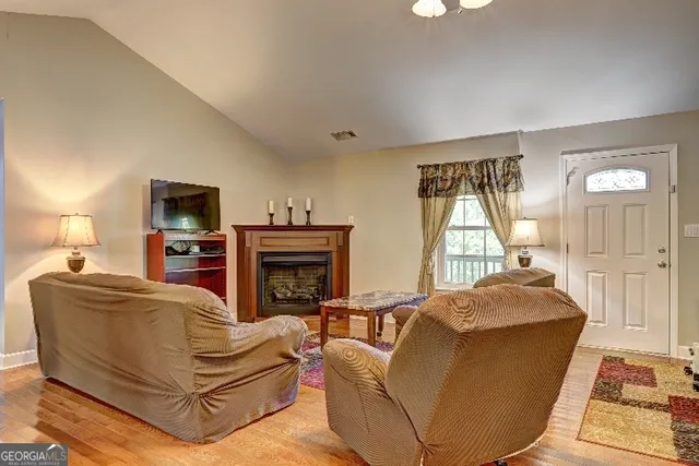 a living room with furniture a window and a flat screen tv