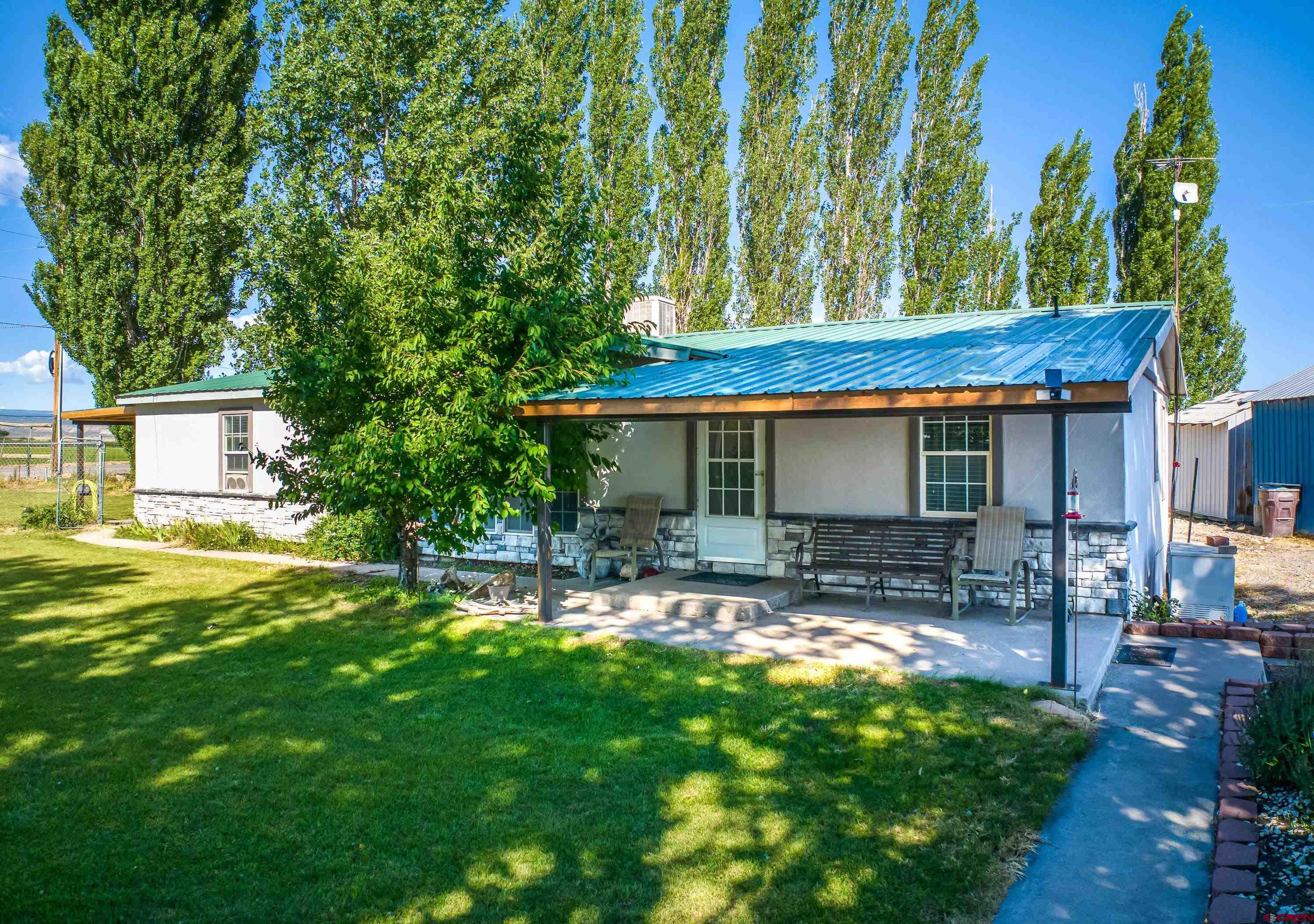 a view of a house with backyard and sitting area
