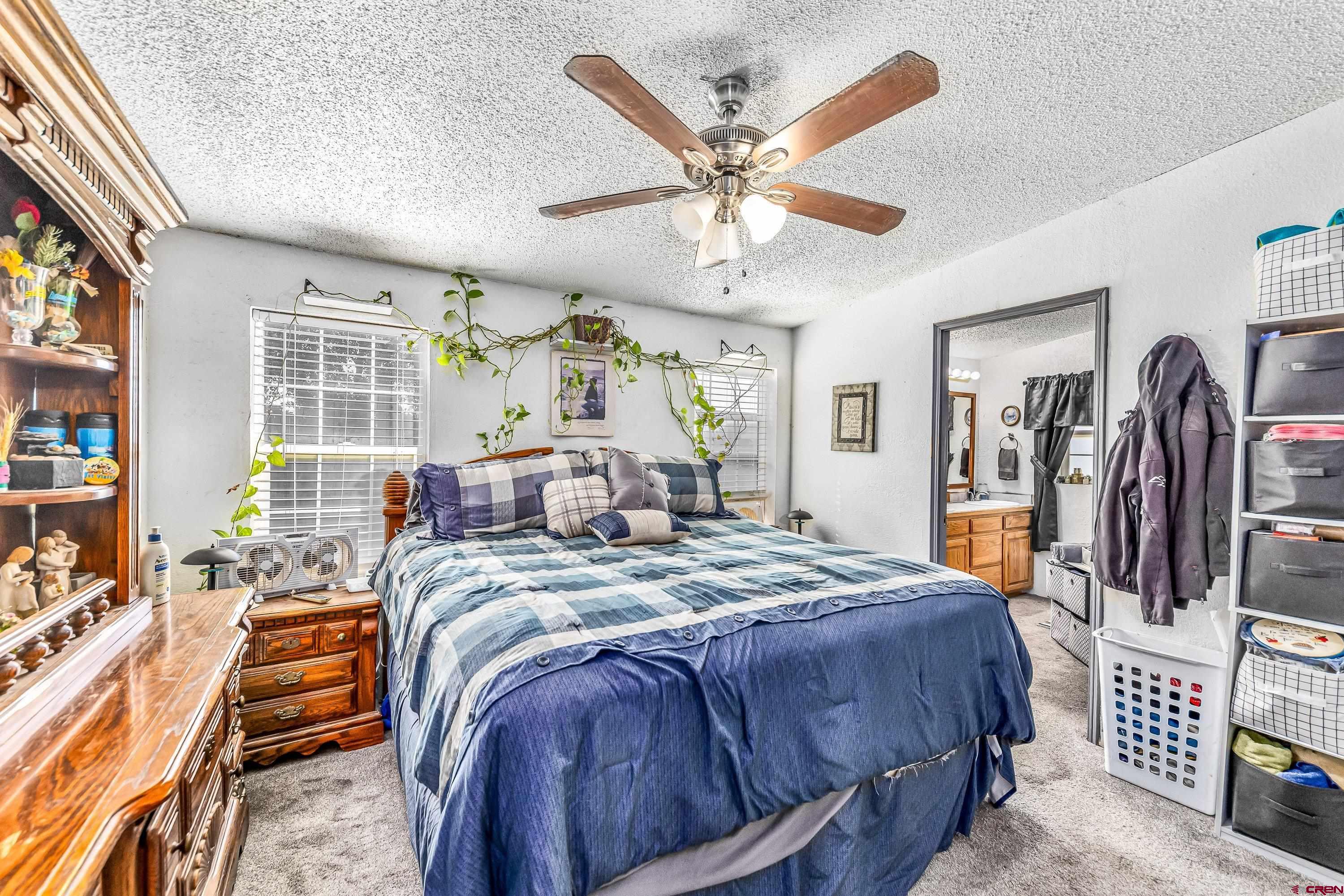 58703 Ida Road Olathe, CO 81425 - Photo 12 of 23 a bed room with a bed and a chandelier