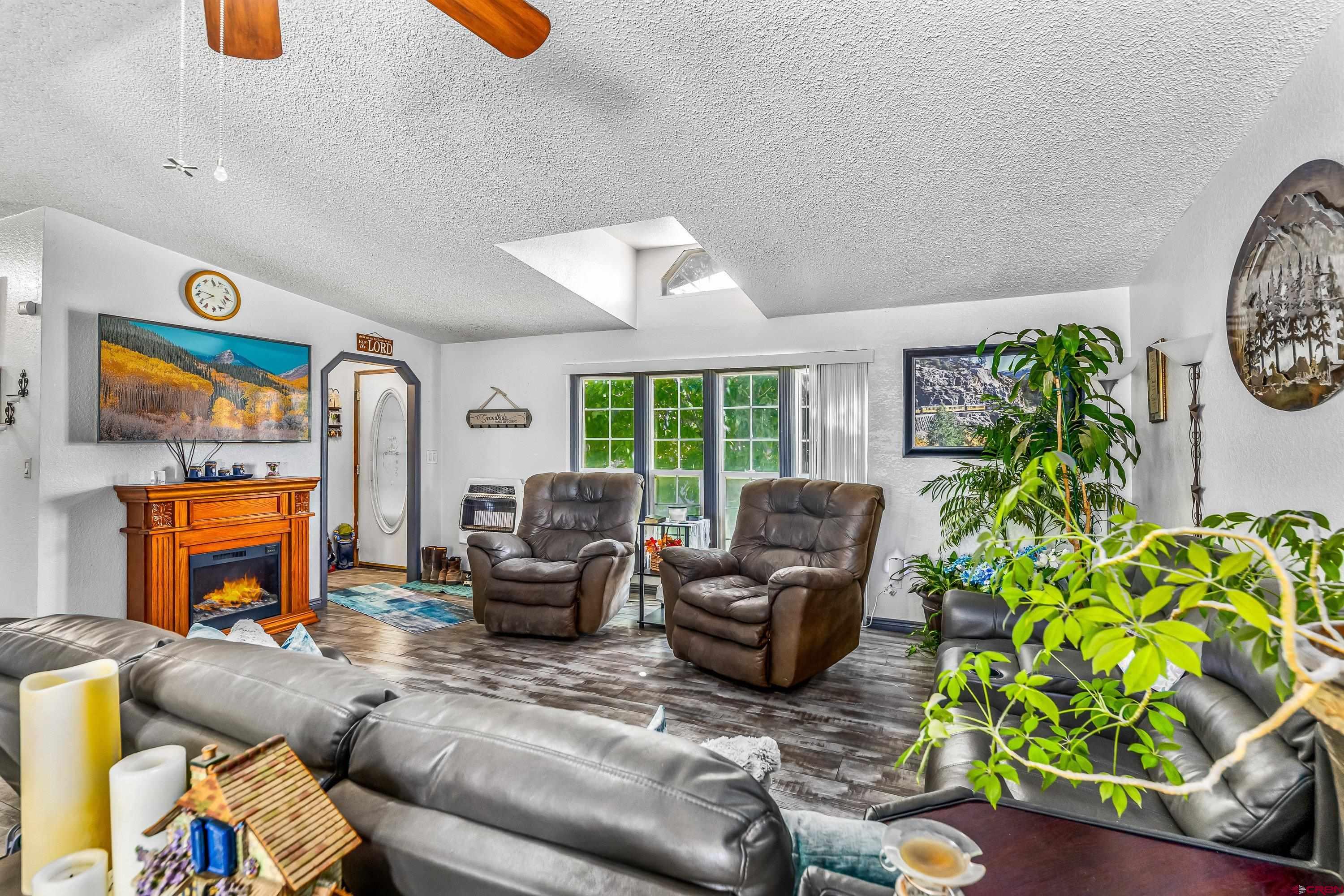 58703 Ida Road Olathe, CO 81425 - Photo 6 of 23 a living room with furniture a fireplace and a potted plant