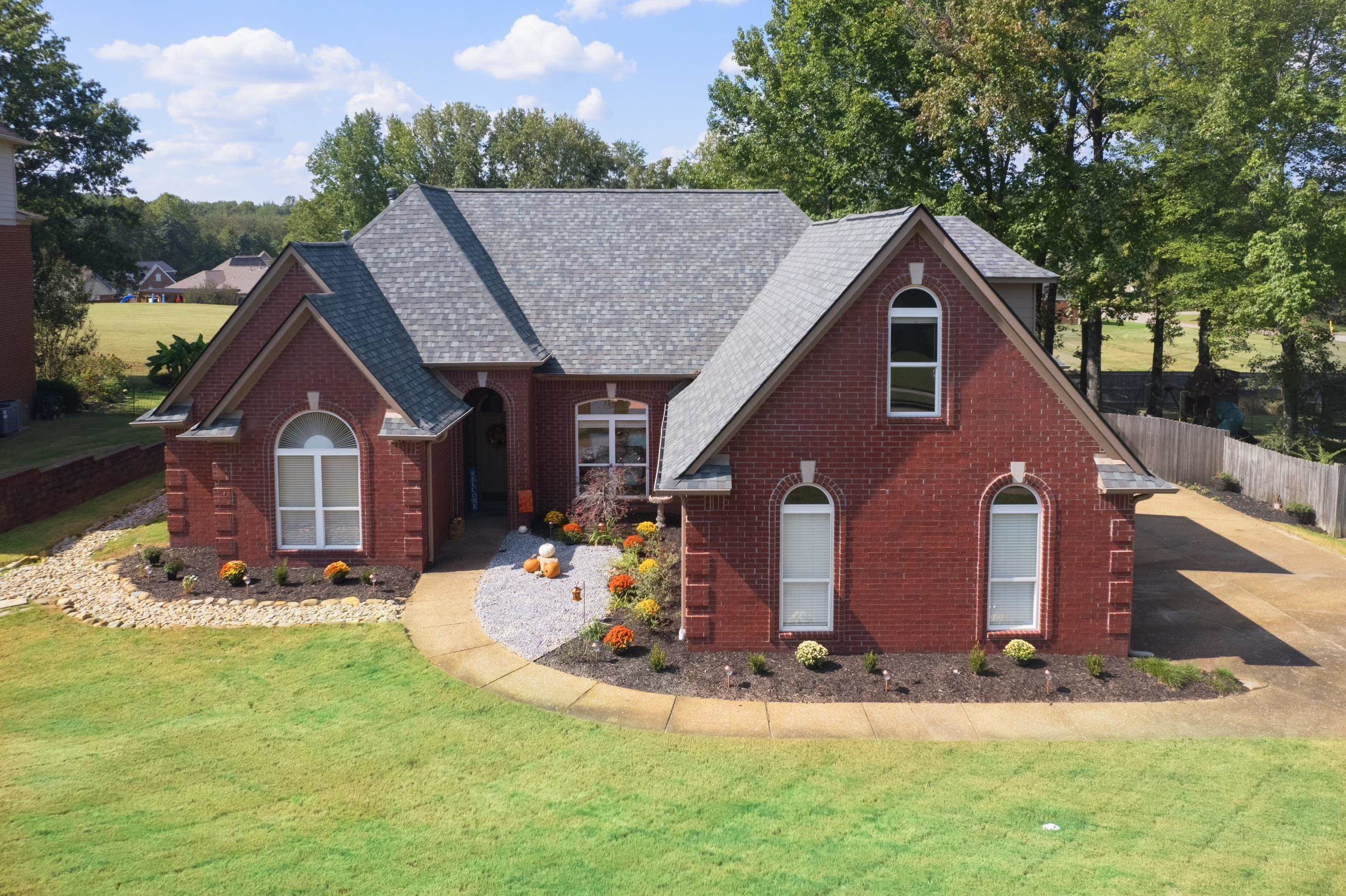 View of front of house featuring brick siding and roof with shingles