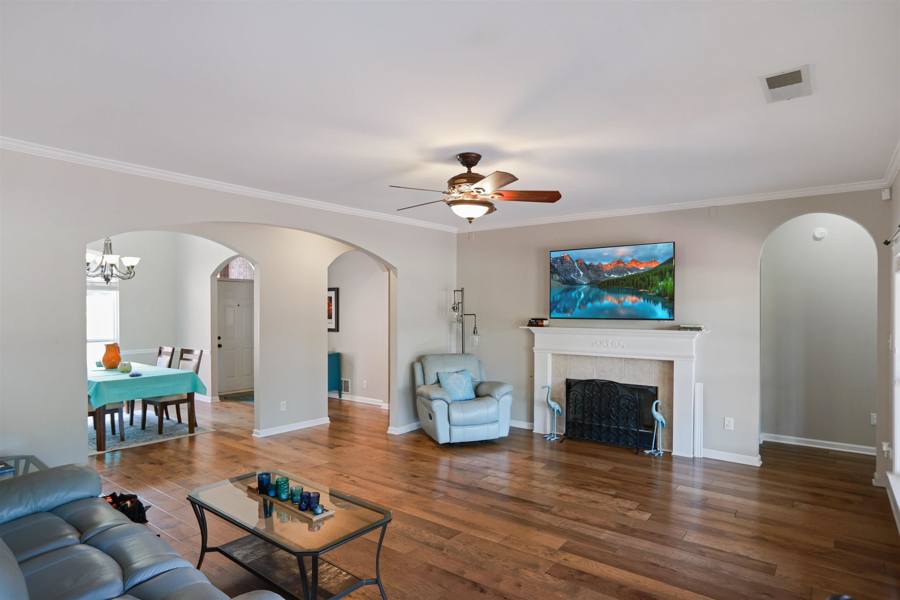 4271 Bay Bridge Road Lakeland, TN 38002 - Photo 8 of 37 Living room with arched walkways, ceiling fan, crown molding, wood finished floors, and a chandelier