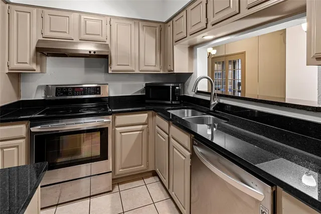 a kitchen with granite countertop a stove and a microwave