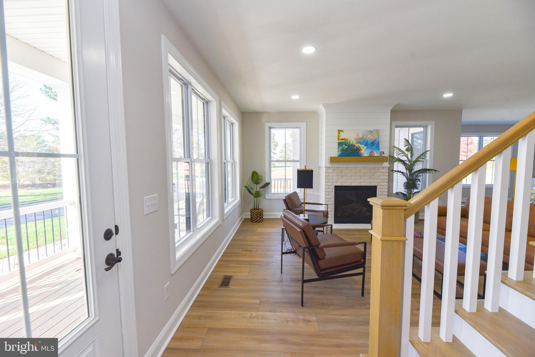 32667 Back Nine Way, Unit 3857 Long Neck, DE 19966 - Photo 12 of 74 a living room with furniture a fireplace and a large window with wooden floor