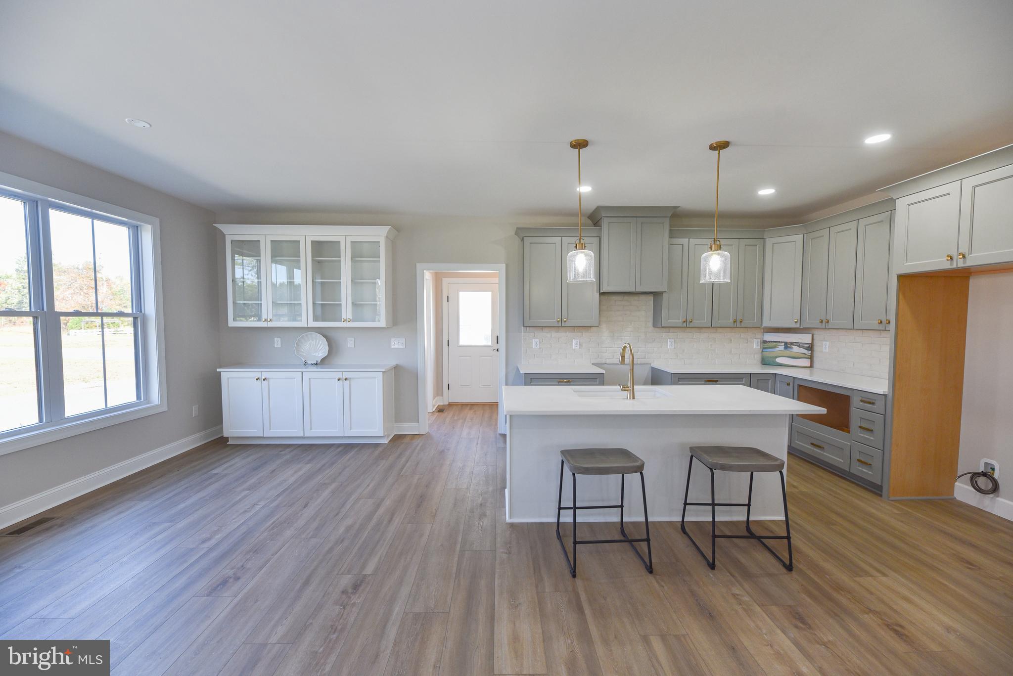 32667 Back Nine Way, Unit 3857 Long Neck, DE 19966 - Photo 21 of 74 a large white kitchen with wooden floor and stainless steel appliances