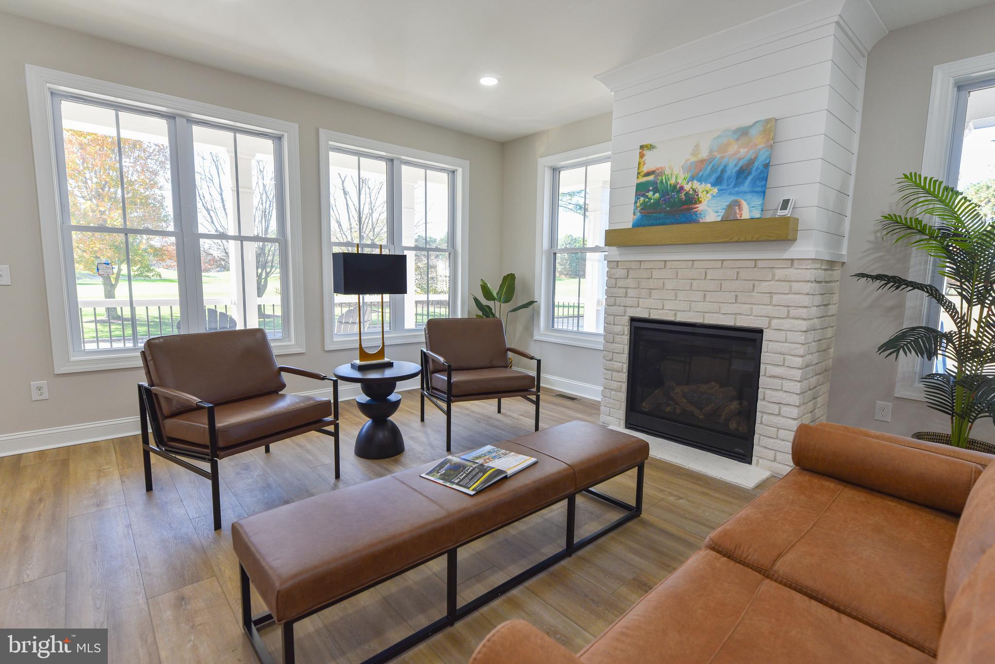 32667 Back Nine Way, Unit 3857 Long Neck, DE 19966 - Photo 38 of 74 a living room with furniture a fireplace and a large window
