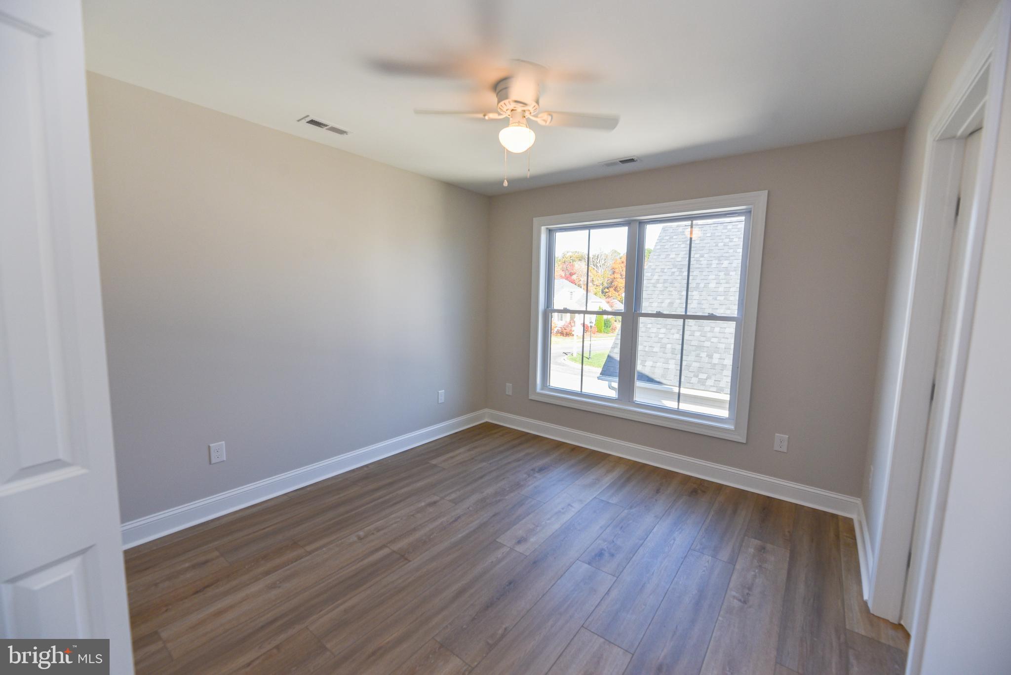 32667 Back Nine Way, Unit 3857 Long Neck, DE 19966 - Photo 57 of 74 an empty room with wooden floor and windows