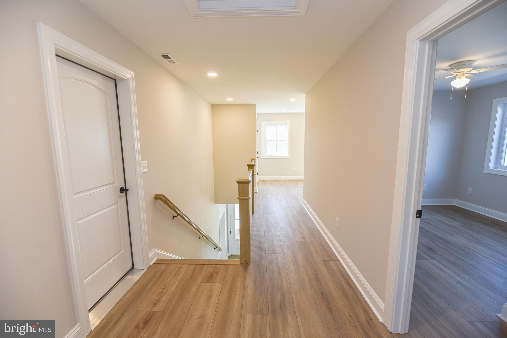 32667 Back Nine Way, Unit 3857 Long Neck, DE 19966 - Photo 61 of 74 a view of a hallway with wooden floor and staircase