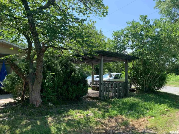 a view of a chair and table in backyard of the house