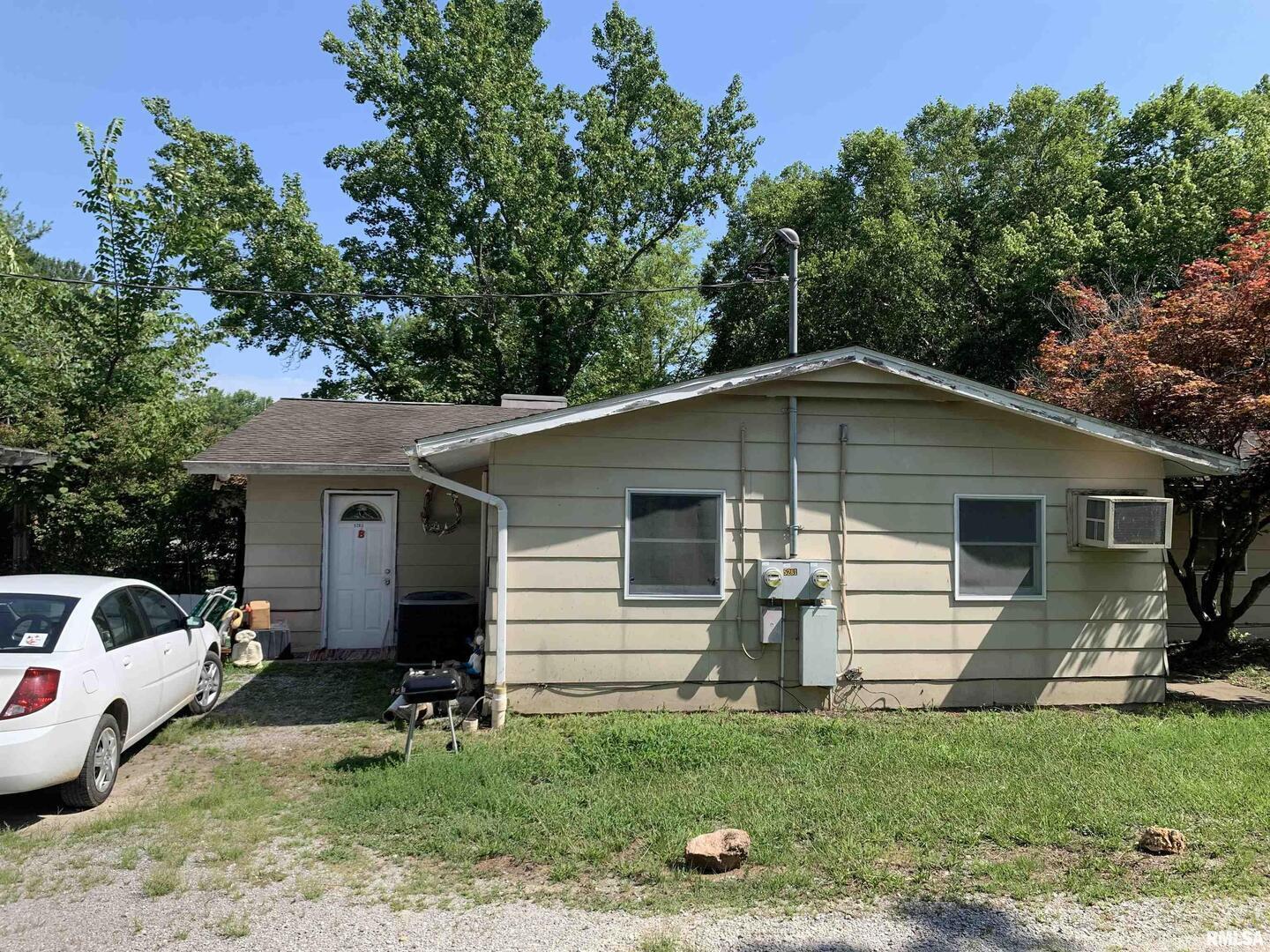 5281-5287 Country Club Road, Unit 2 Murphysboro, IL 62966 - Photo 2 of 27 a view of a yard in front of a house with plants and large tree
