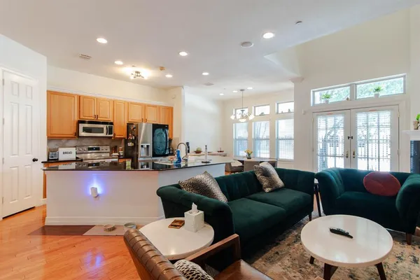 a kitchen with stainless steel appliances a sink a stove a microwave a refrigerator a window