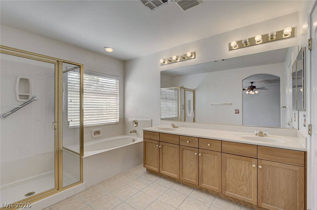 1479 Orange Jubilee Road Henderson, NV 89014 - Photo 21 of 36 Double vanity with ample storage and a separate shower and soaking tub create a functional primary bathroom.