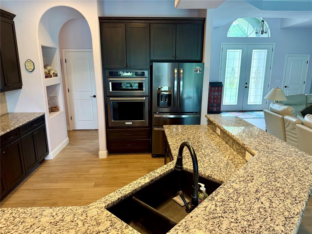 13110 Bamboo Street Spring Hill, FL 34609 - Photo 10 of 56 a large kitchen with kitchen island granite countertop a stove refrigerator and sink