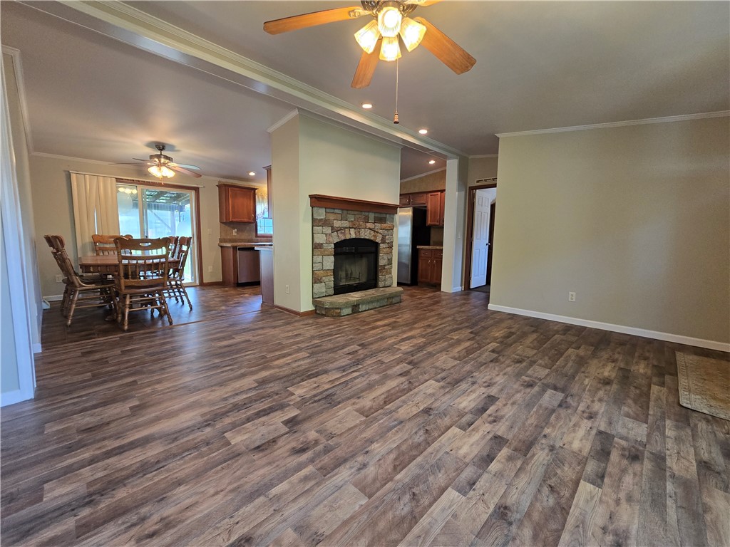 5337 State Rte 26 Triangle, NY 13862 - Photo 3 of 22 Rich wood-look flooring and a stone-faced fireplace anchor the comfortable open-concept living area.