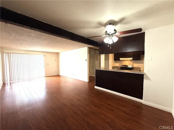 a view of a kitchen with wooden floor and a ceiling fan