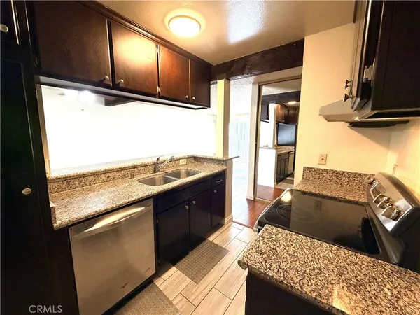 a kitchen with stainless steel appliances kitchen island granite countertop a sink stove and refrigerator
