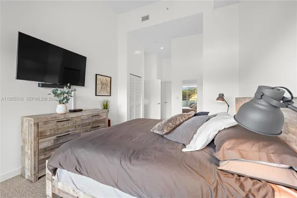 a bedroom with a bed and a potted plant