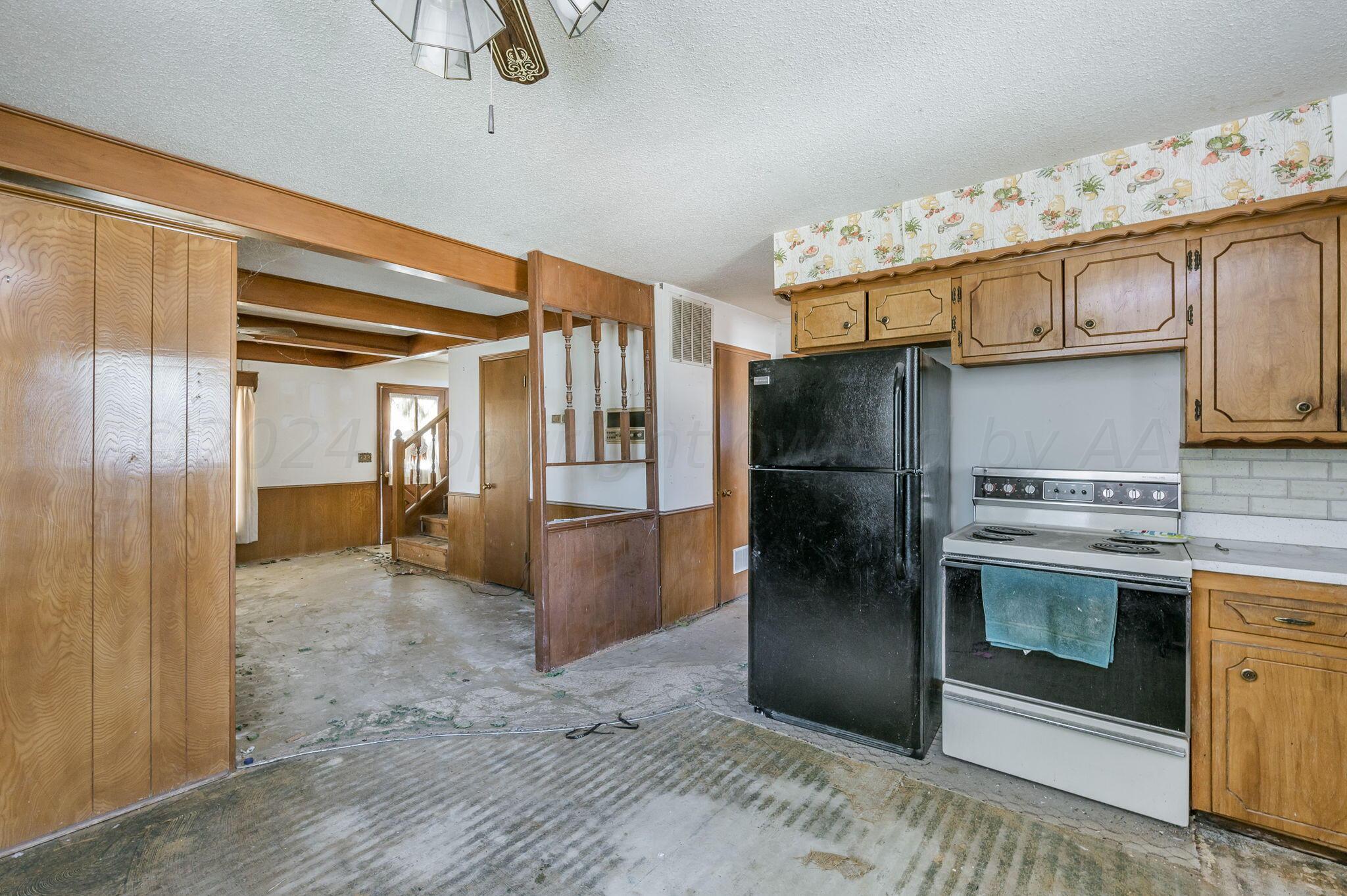 503 Cherry Avenue Dumas, TX 79029 - Photo 6 of 13 a kitchen with granite countertop a refrigerator and a sink
