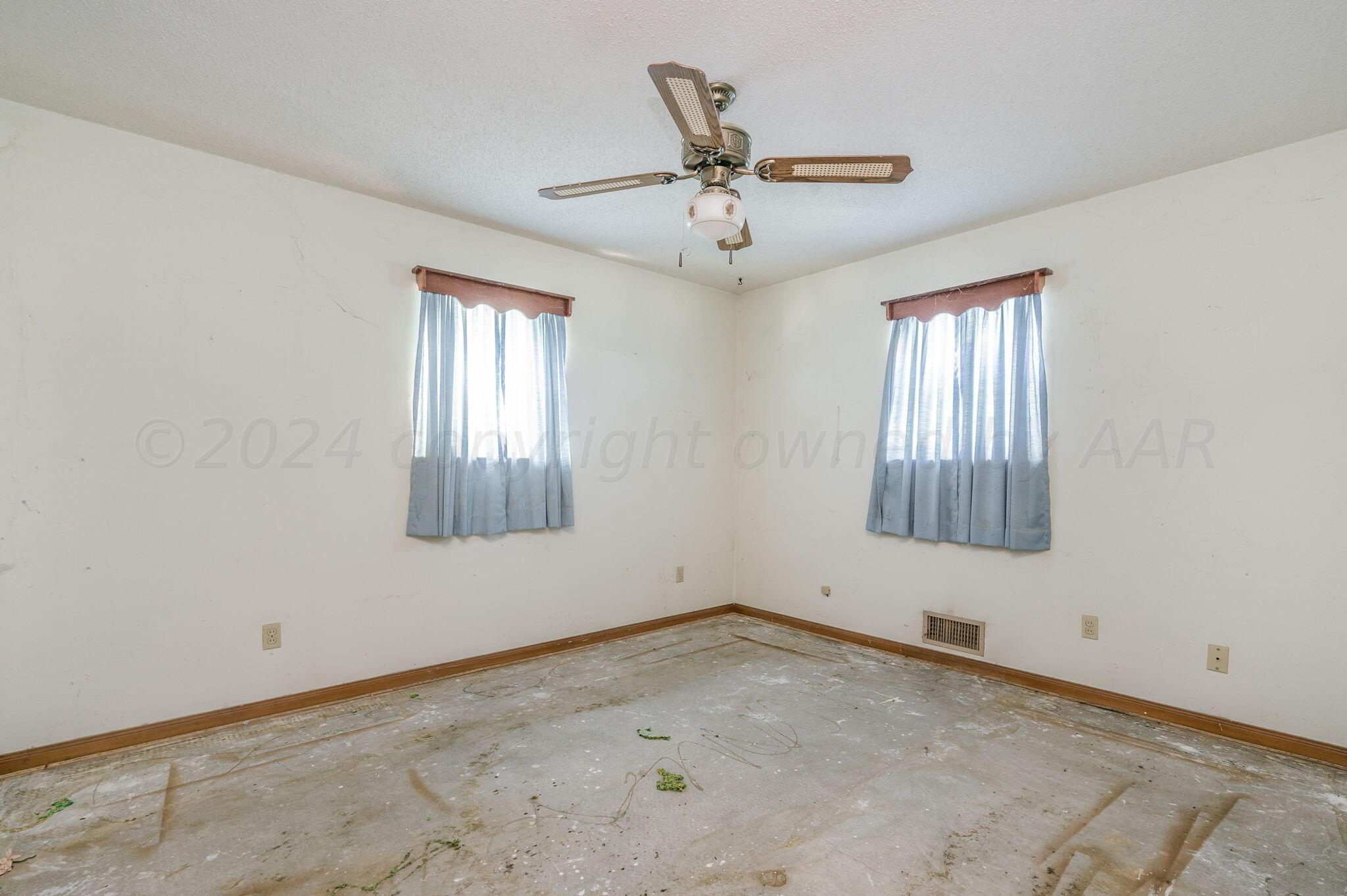 503 Cherry Avenue Dumas, TX 79029 - Photo 8 of 13 an empty room with windows and fan