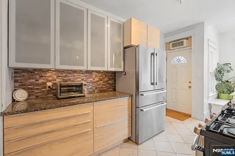 a kitchen with stainless steel appliances granite countertop a refrigerator and a stove