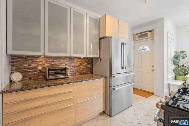 a kitchen with stainless steel appliances granite countertop a refrigerator and a stove
