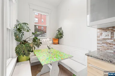 a white table with chairs and a potted plant