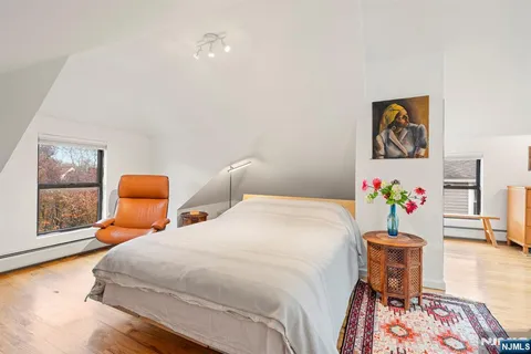a bedroom with natural light and wooden floor