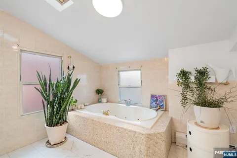 a bath tub sitting in a bathroom next to a potted plant