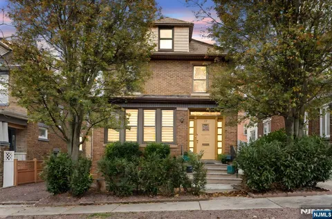 a front view of a house with a tree