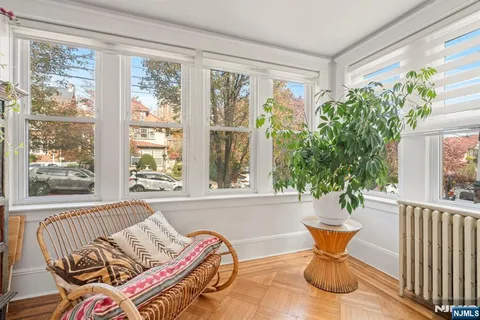 a living room with patio furniture and a potted plant