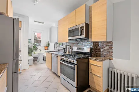 a kitchen with stainless steel appliances a stove a sink and a refrigerator
