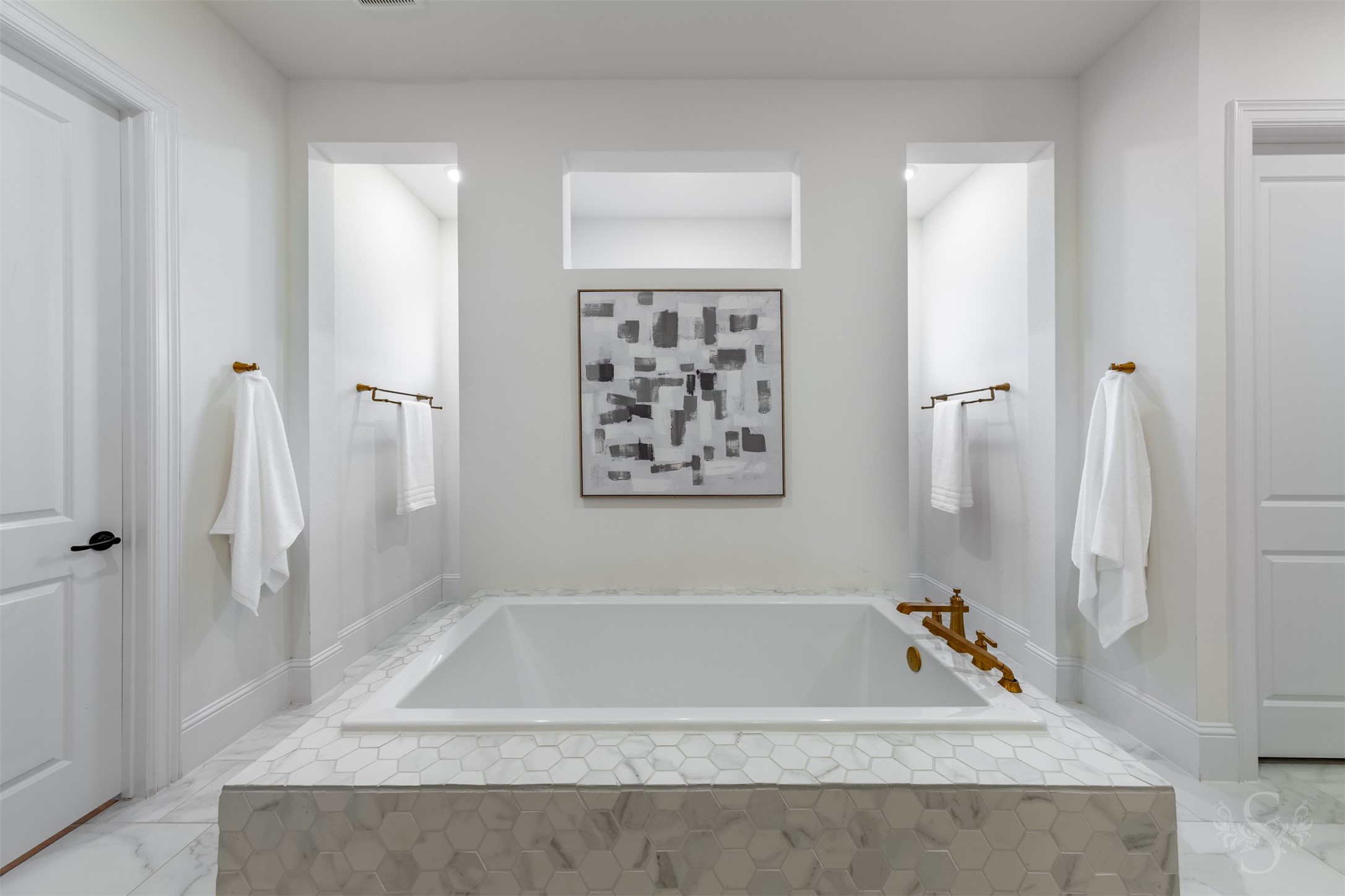 27919 Indigo Ridge Drive Fulshear, TX 77441 - Photo 28 of 50 The centerpiece of the primary bath is the luxurious soaking tub wrapped in designer hex tile, flanked by dual entrances leading into the expansive walk-through shower. Elegant gold fixtures and soft architectural lighting create a serene, spa-like escape perfect for unwinding.