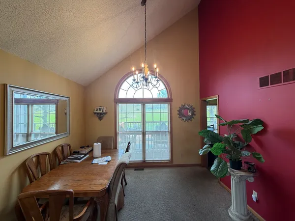 a view of a dining room with furniture and a chandelier