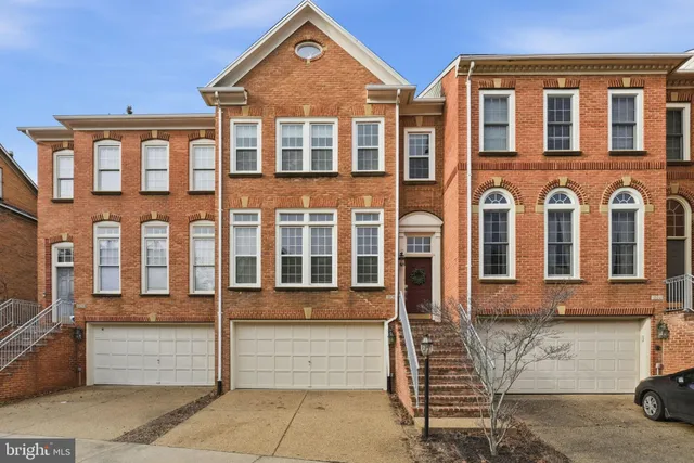 front view of a brick house with a yard